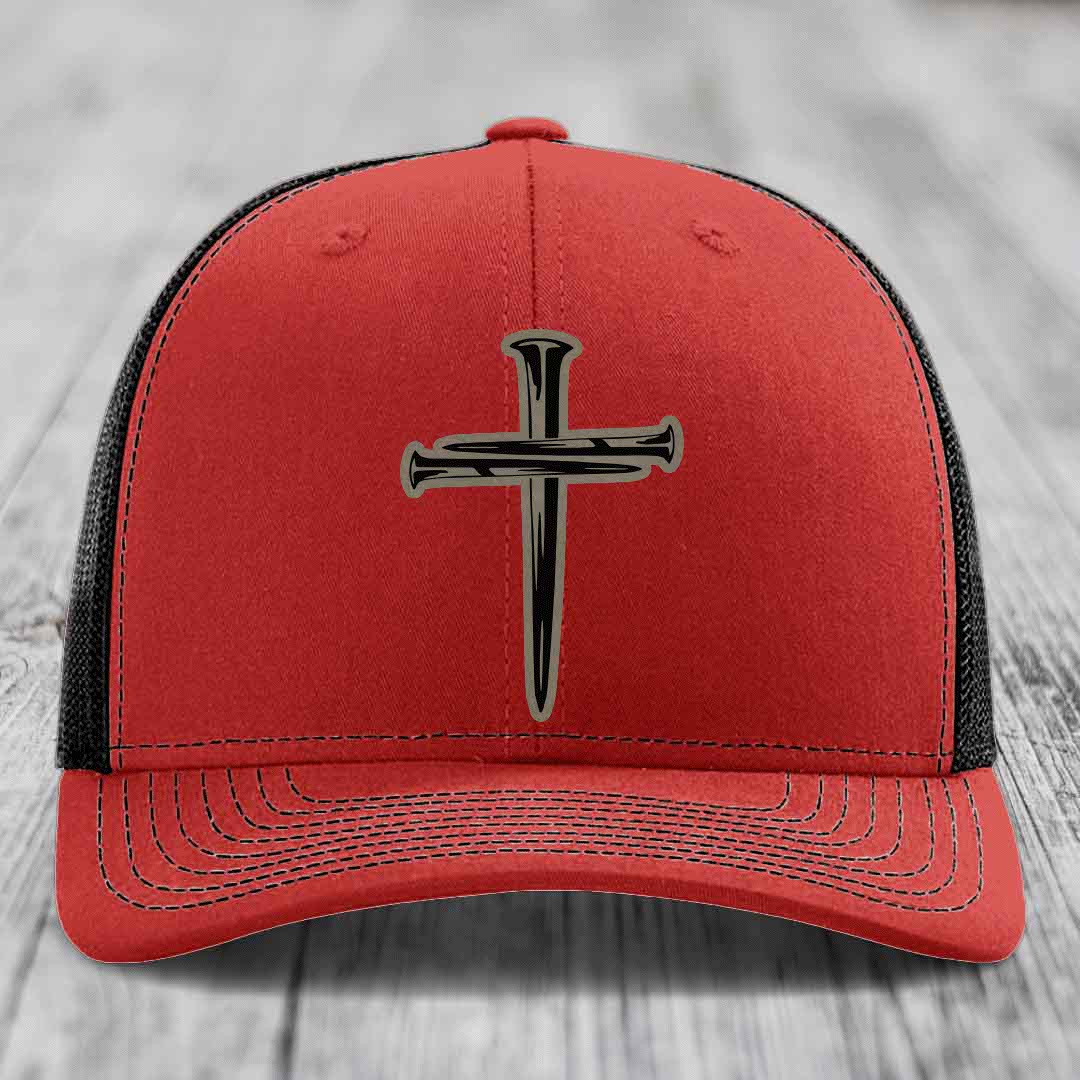 Blue trucker hat with black and tan cross of nails patch on front.
