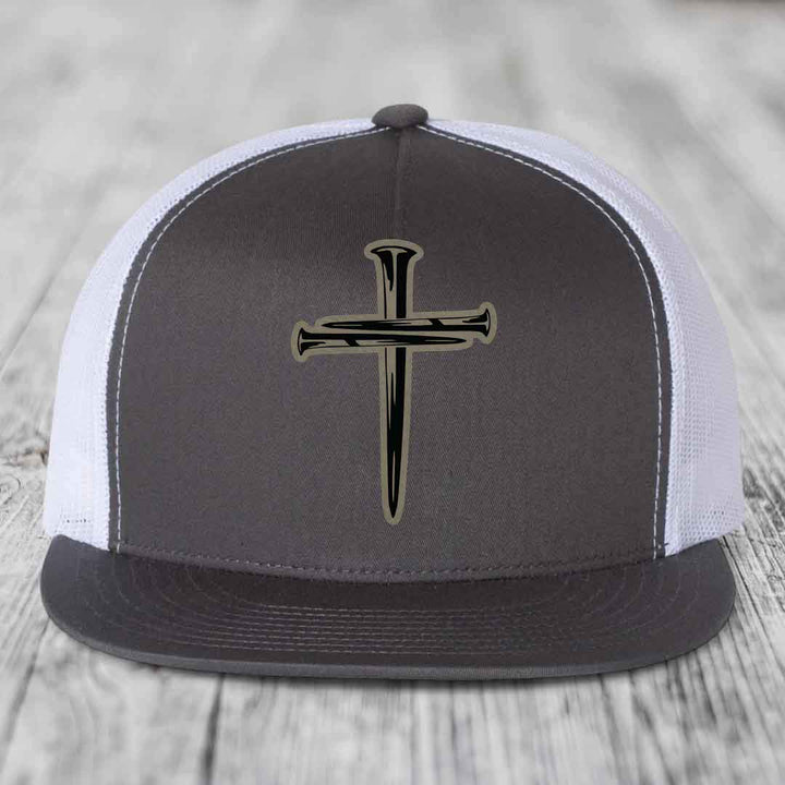 Black snapback hat with a cross made of nails patch on front.