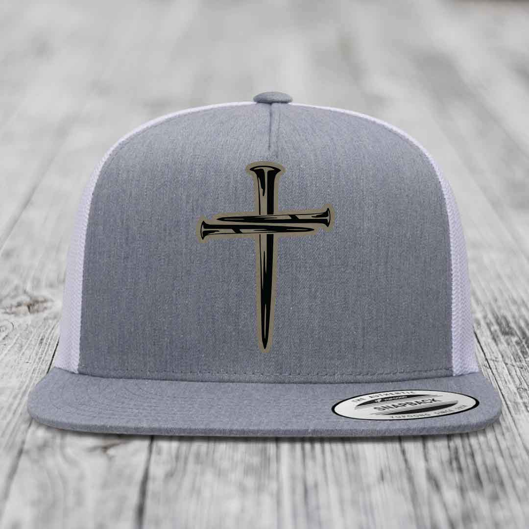 Grey and white trucker hat with a cross made of nails patch on front.