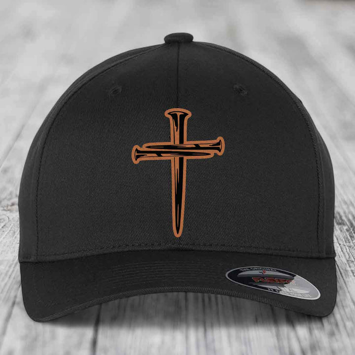Black baseball cap with a brown and black cross of nails patch on front.