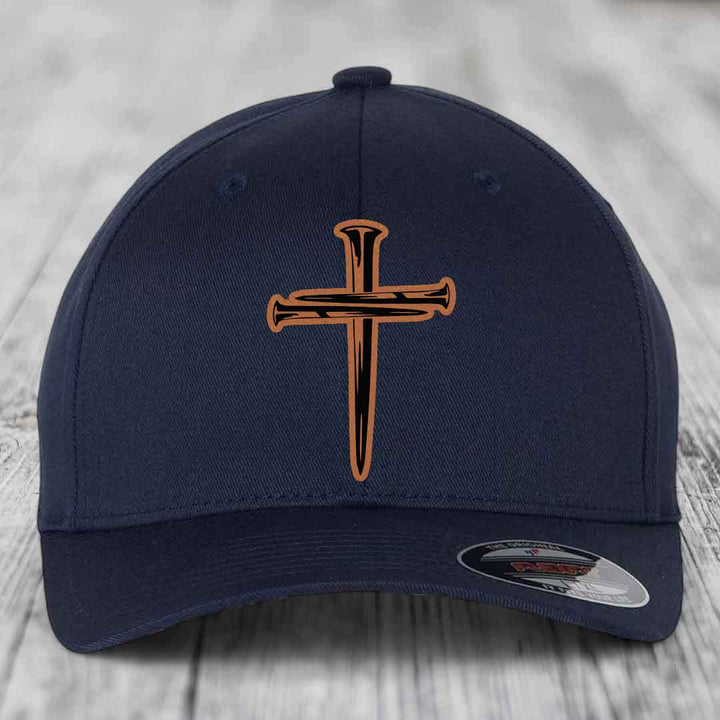 Red baseball cap with black and tan cross of nails patch on front.