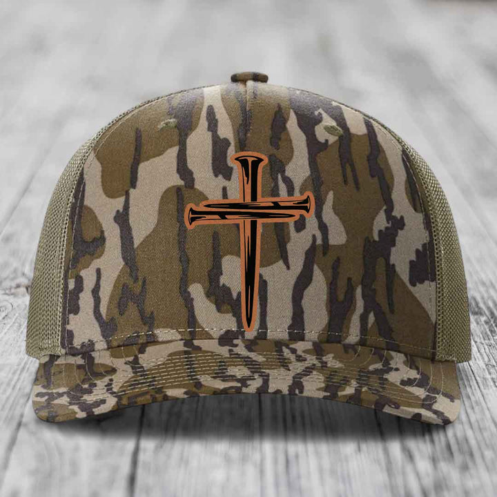 Blue and white trucker hat with a cross made of nails patch on front.