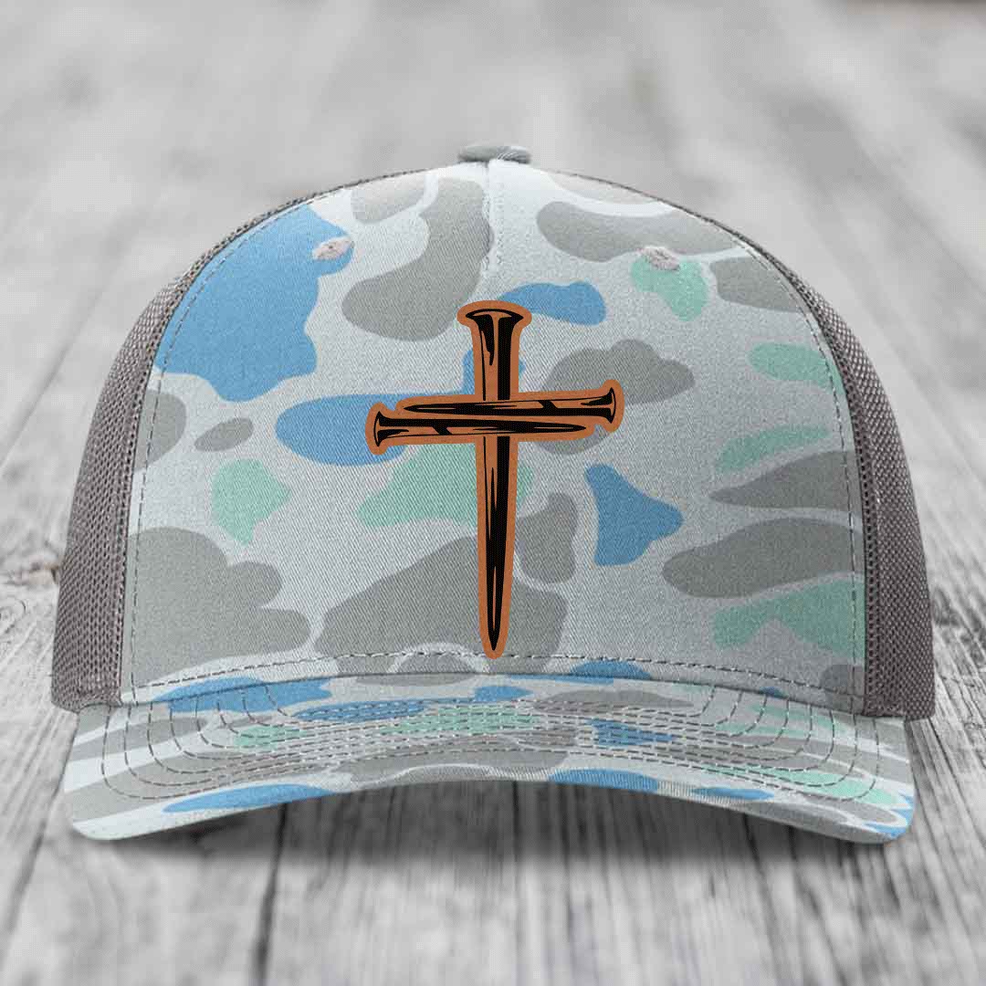 Camouflage trucker hat with a cross made of nails design on front.