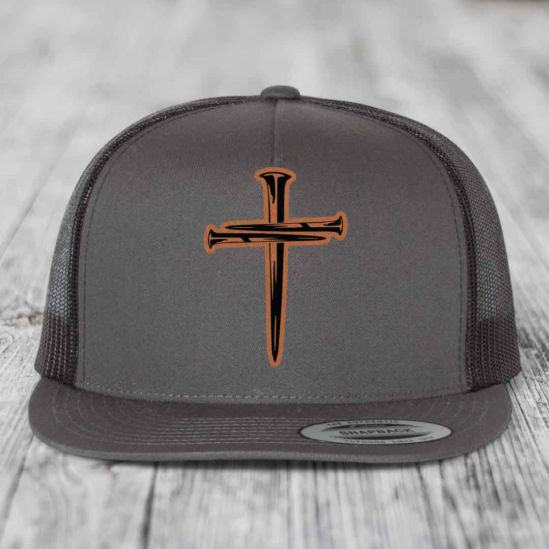 Grey trucker hat with black mesh back and orange cross of nails leather patch on front.