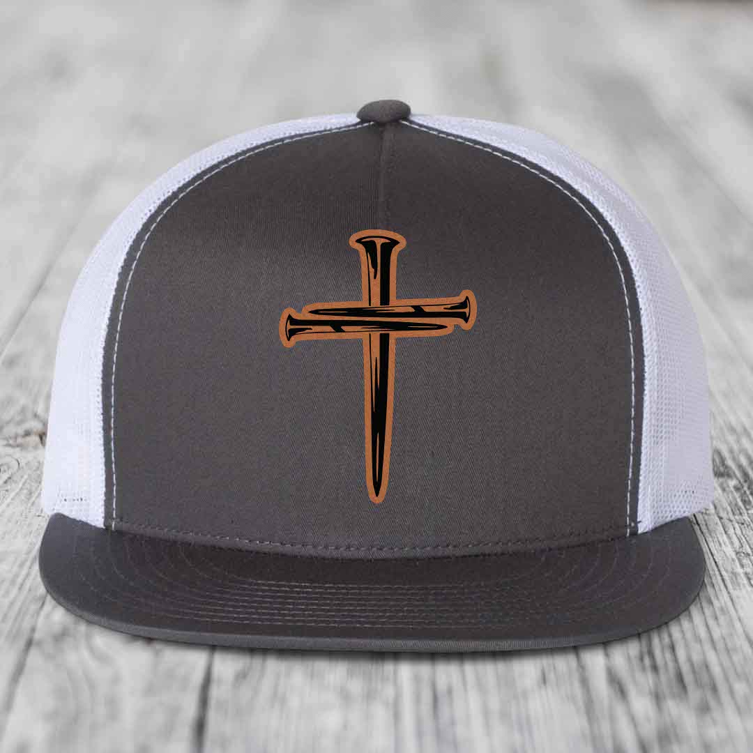 Black snapback hat with a cross made of nails patch on front.