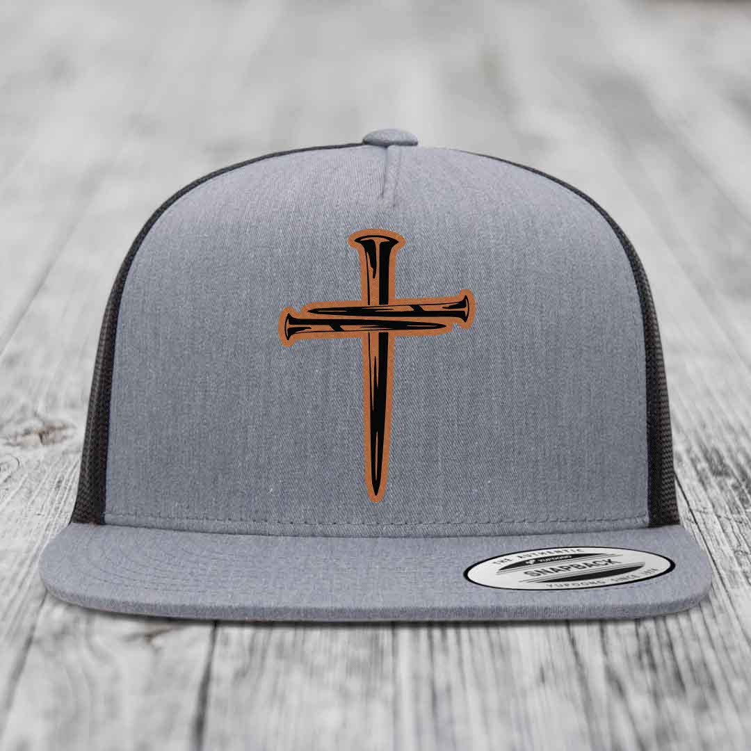 Grey trucker hat with black and orange cross of nails leather patch on front.