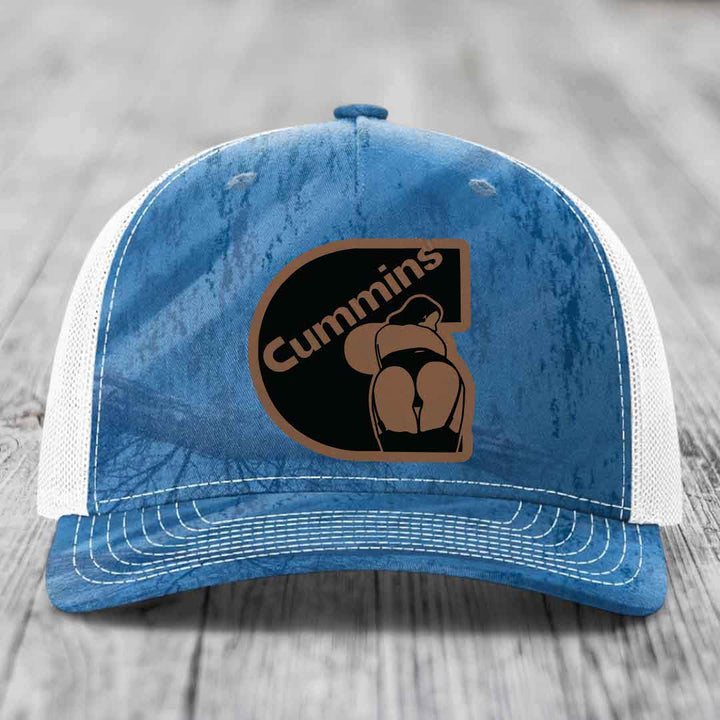 Camouflage trucker hat with brown leather patch featuring &