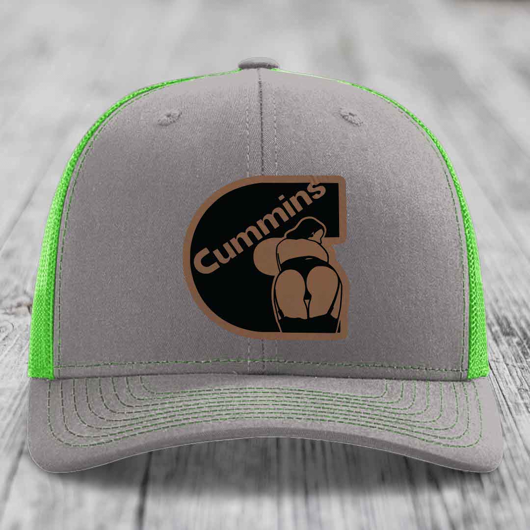 Grey trucker hat with orange mesh back and brown Cummins logo patch.