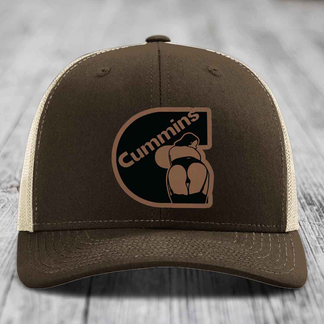 Green trucker hat with brown Cummins logo patch featuring a stylized engine graphic.