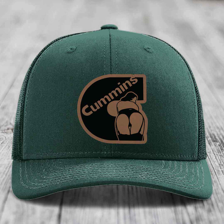 Grey trucker hat with black and brown Cummins logo patch on front.