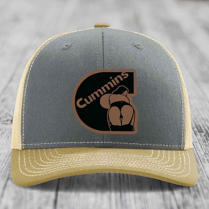 Grey trucker hat with black mesh back and brown leather patch featuring &