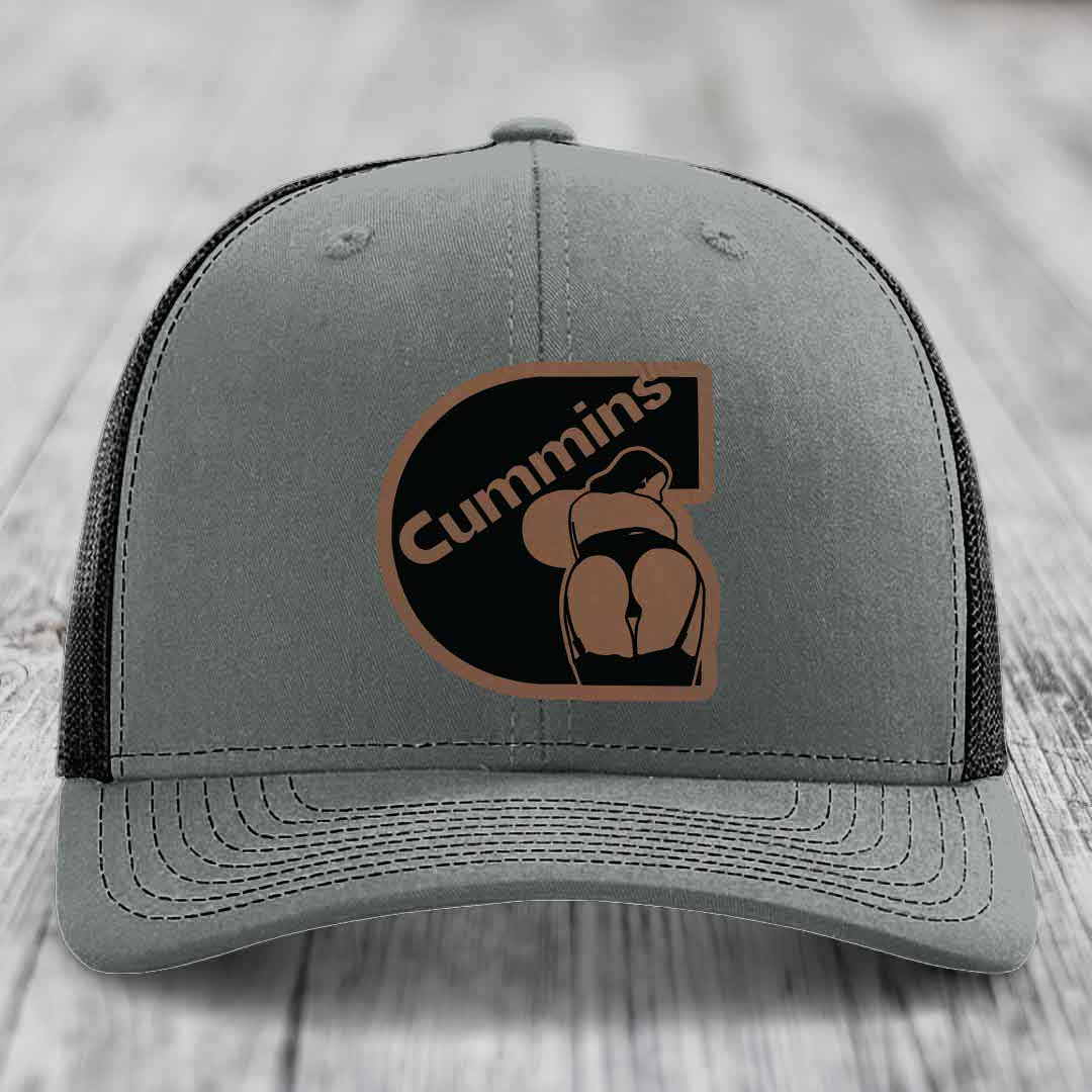 Grey trucker hat with white mesh back and embroidered Cummins logo patch.