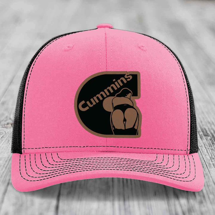 Green trucker hat with white mesh back and brown Cummins logo patch.