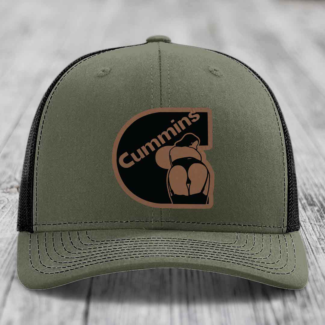 Black trucker hat with brown Cummins logo patch featuring a stylized engine design.