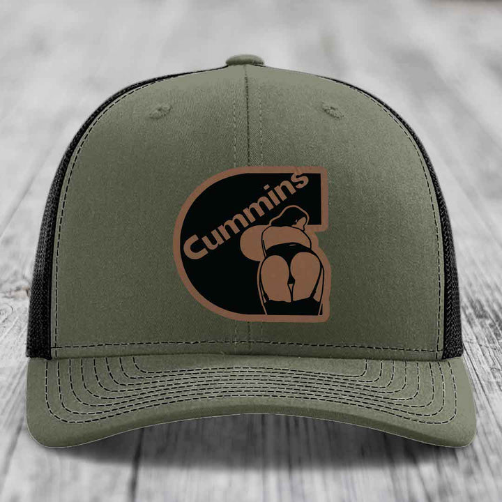 Black trucker hat with brown Cummins logo patch featuring a stylized engine design.