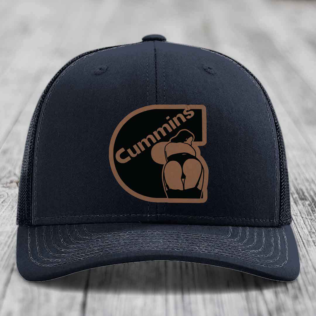 Purple trucker hat with black and tan Cummins logo patch on front.