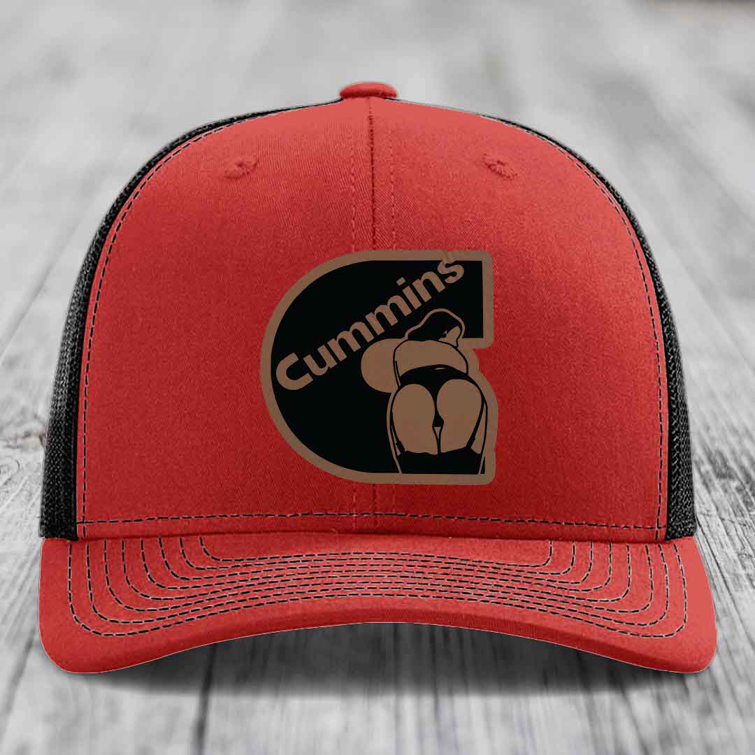 Blue trucker hat with black mesh back and brown Cummins logo patch on front.