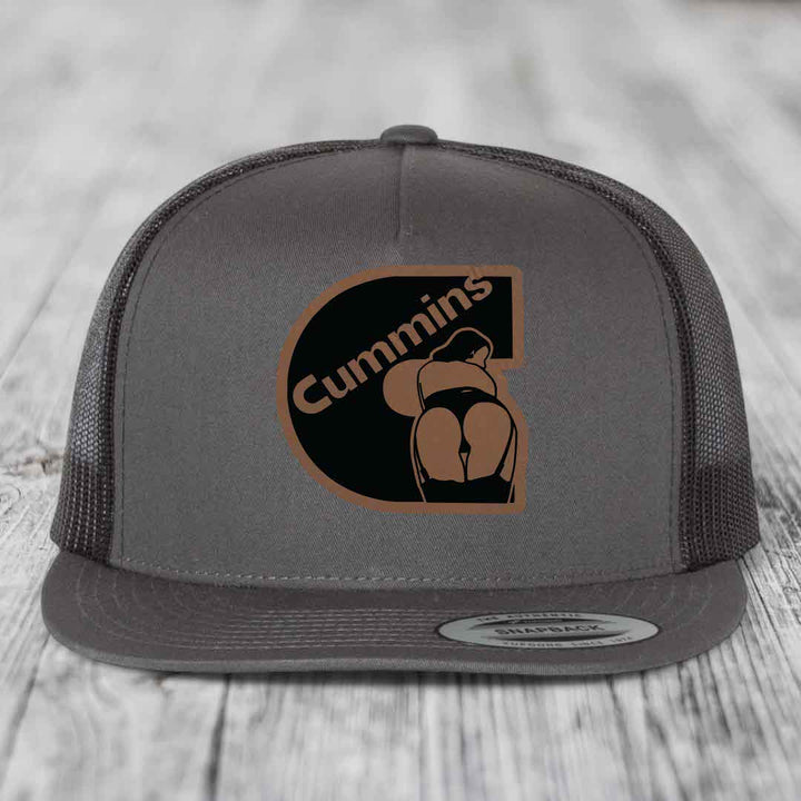 Grey trucker hat with brown and black Cummins logo patch featuring a stylized figure.