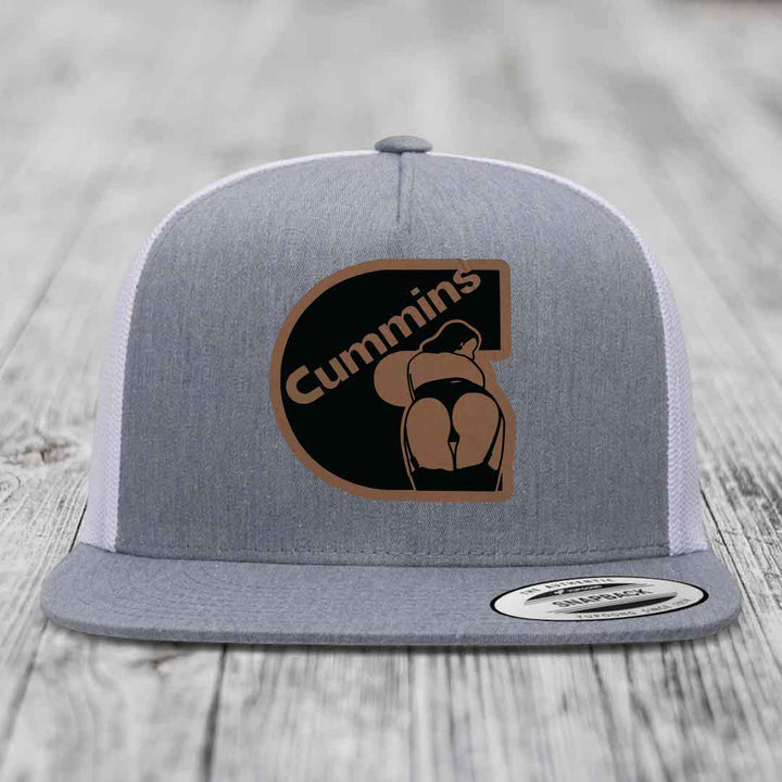 Grey front panel trucker hat with brown Cummins logo patch, white mesh back, and grey brim.