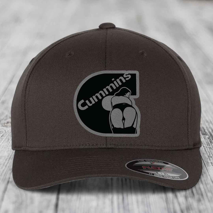 Beige baseball cap with black and grey Cummins logo patch on front.