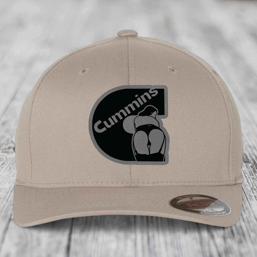 Beige baseball cap with black and grey Cummins logo patch on front.