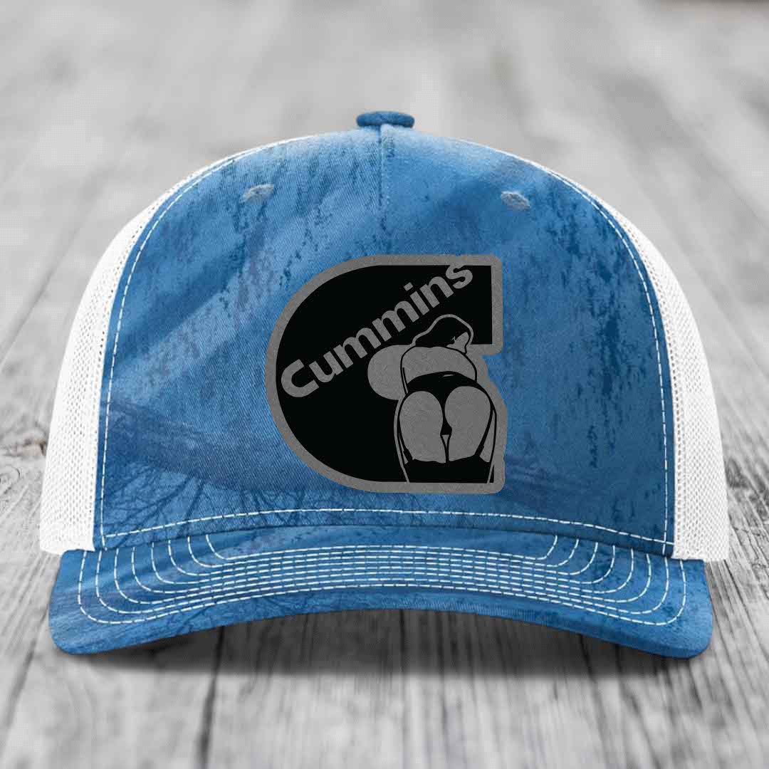 Camouflage trucker hat with black Cummins logo patch on front.