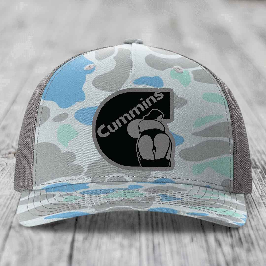 Camouflage trucker hat with Cummins logo patch on front, black mesh back.