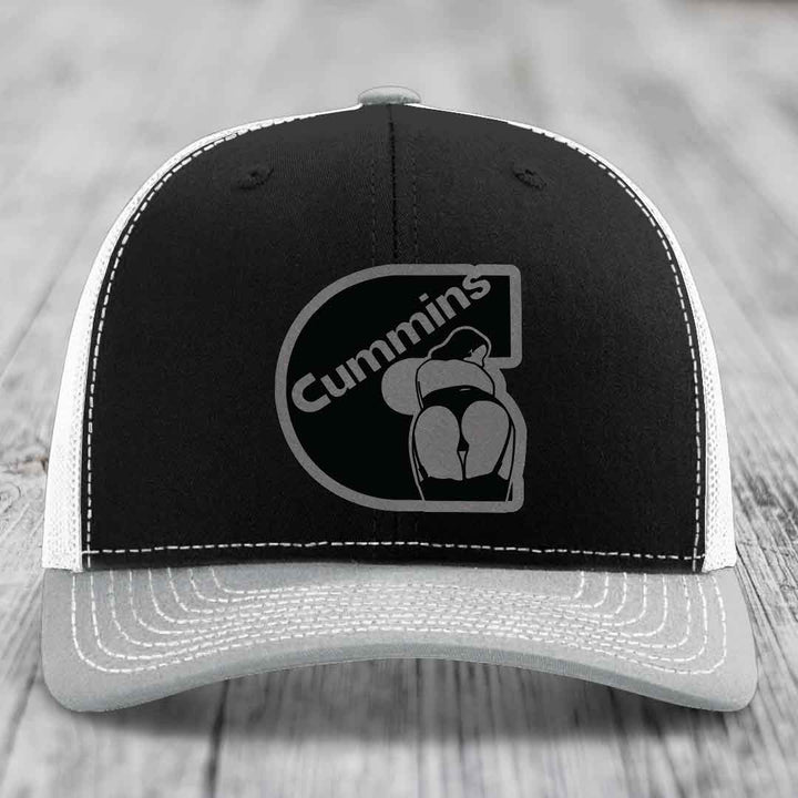 Brown trucker hat with white stitching and a black Cummins logo patch on front.