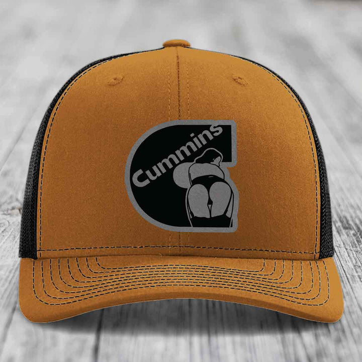Grey trucker hat with black mesh back and Cummins logo patch on front.