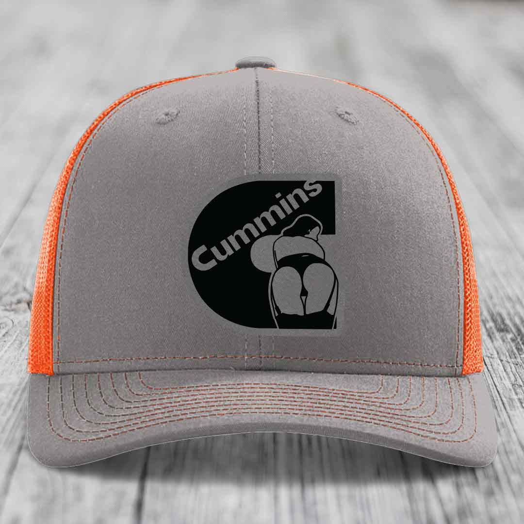 Grey trucker hat with pink mesh sides and a black Cummins logo patch on front.