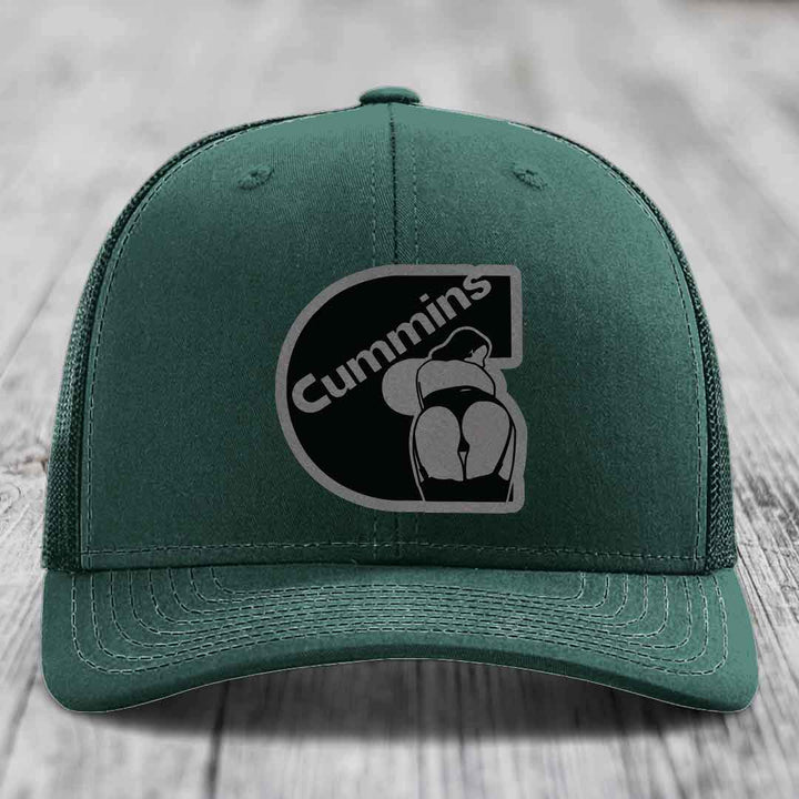 Grey trucker hat with black Cummins logo patch featuring a stylized &