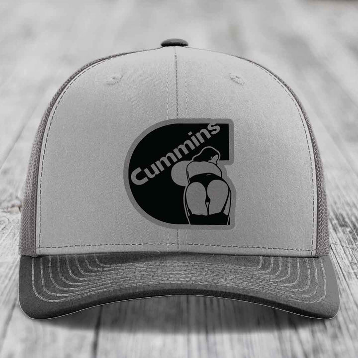Grey and beige trucker hat with black Cummins logo patch on front.