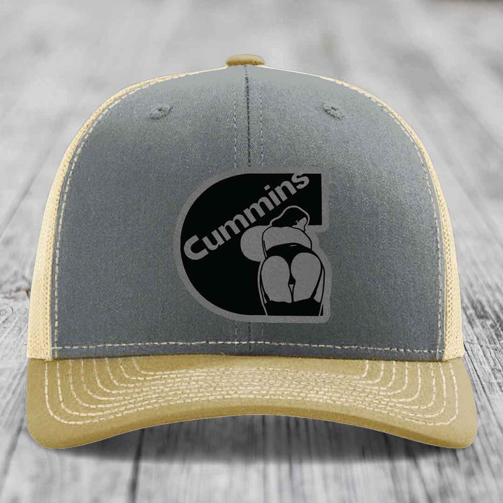 Grey trucker hat with black Cummins logo patch featuring a stylized figure.