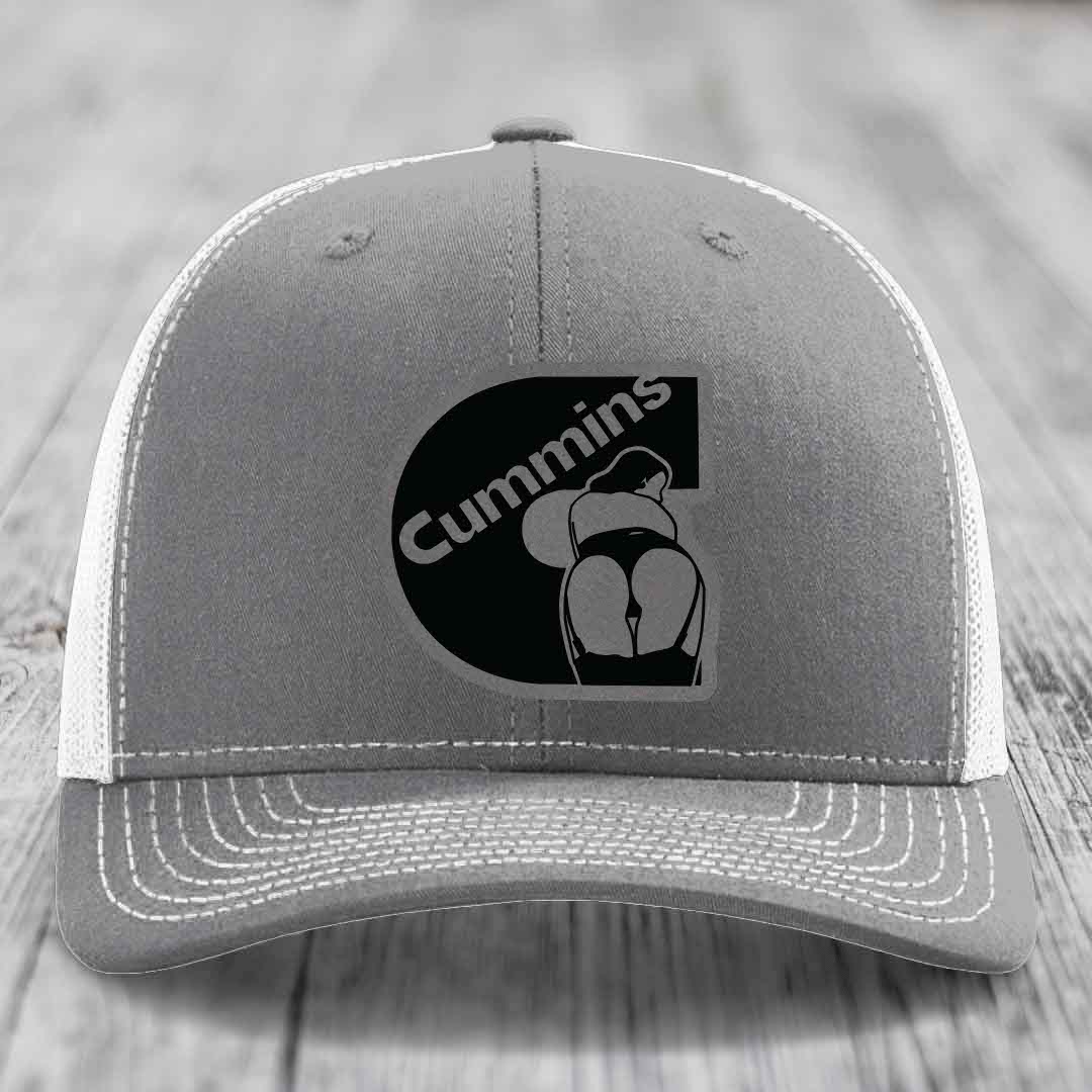 Pink trucker hat with black mesh back and gray Cummins logo patch on front.