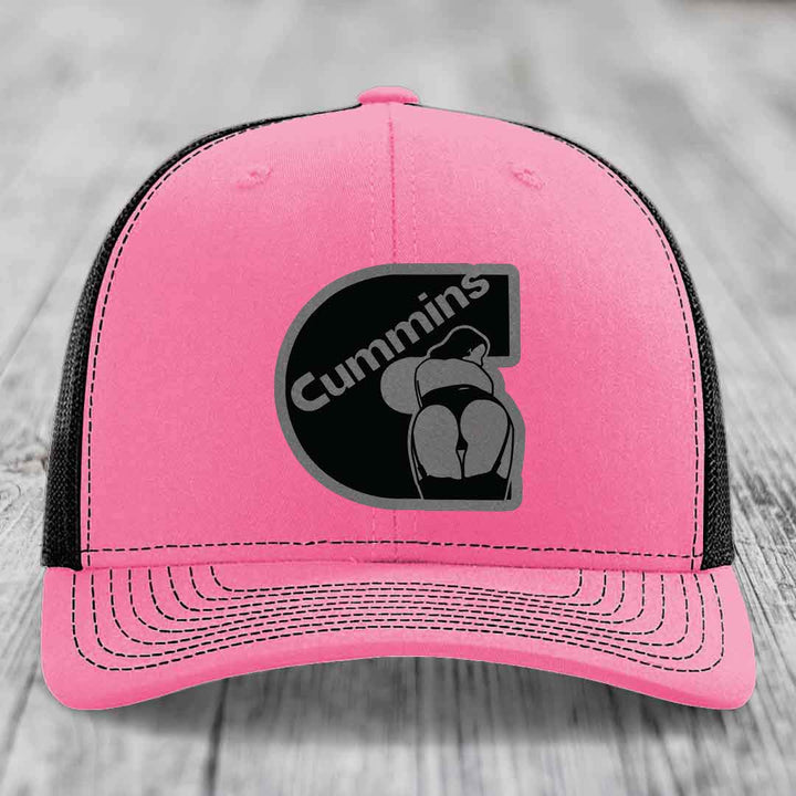 Green trucker hat with white mesh back and embroidered Cummins logo patch.