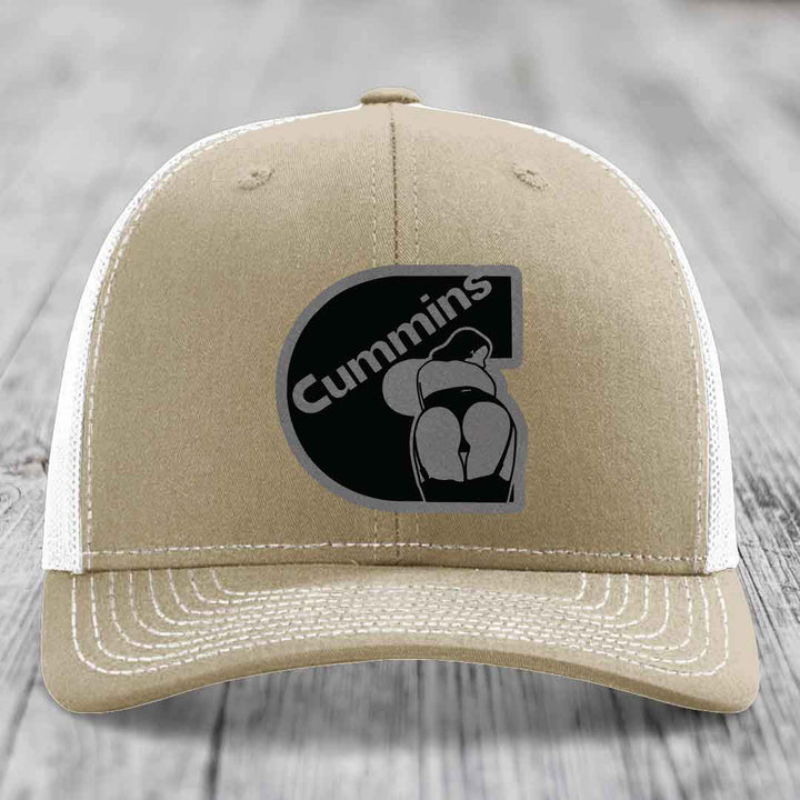 Olive green trucker hat with black Cummins logo patch featuring a stylized engine graphic.