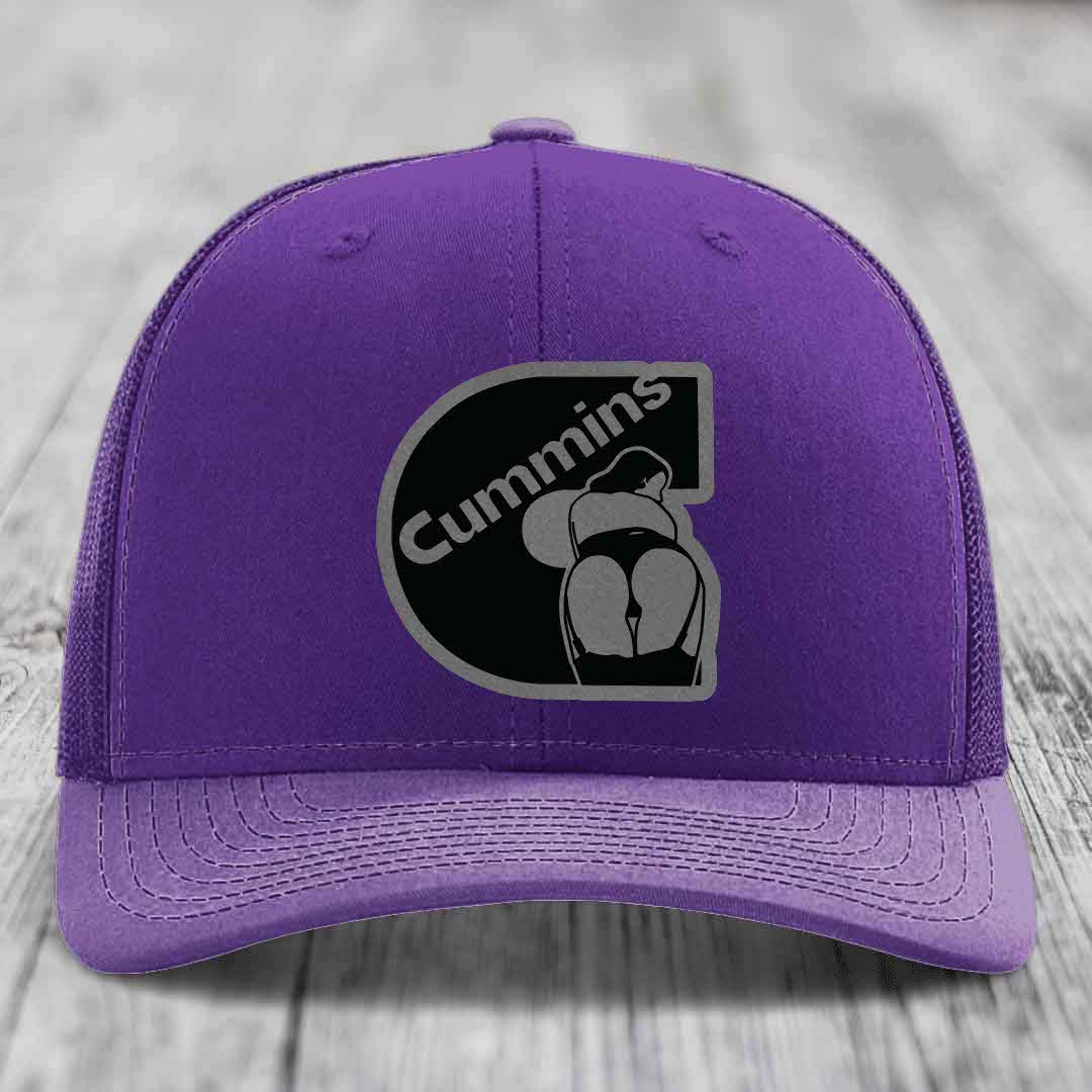 Red trucker hat with black mesh back and gray stitched Cummins logo patch on front.