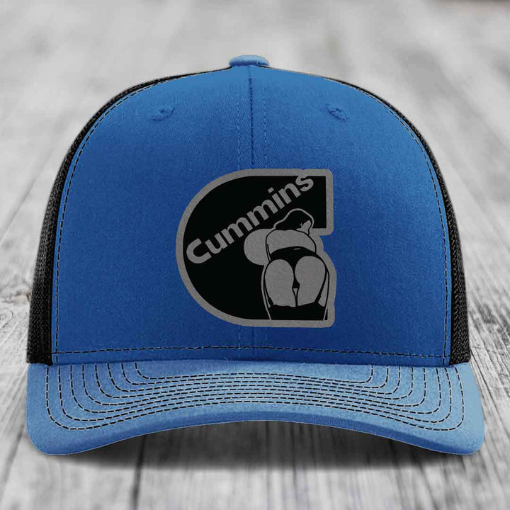 Blue and red trucker hat with Cummins logo patch on front, white stitching, and mesh back.