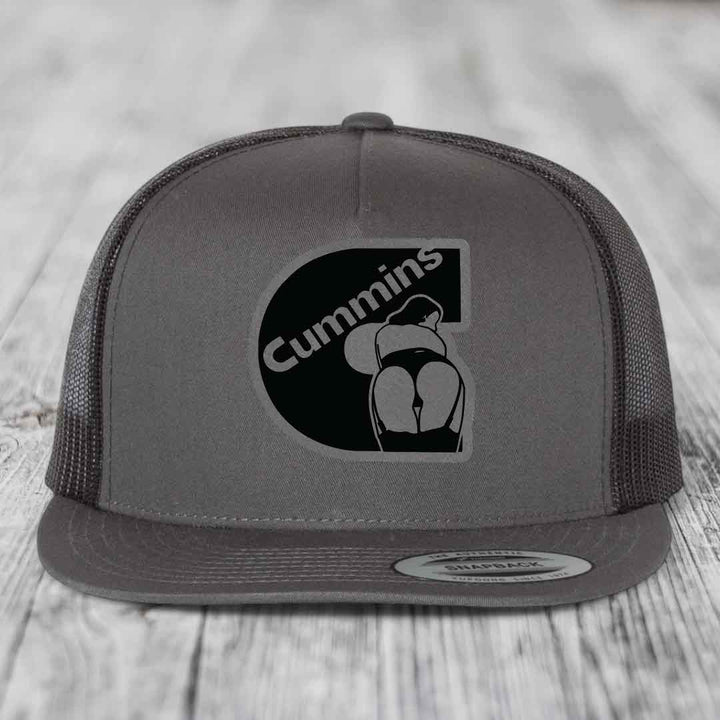 Grey trucker hat with black Cummins logo patch featuring a stylized &