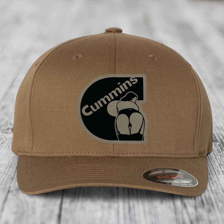 Tan baseball cap with black Cummins logo patch featuring a stylized engine graphic.