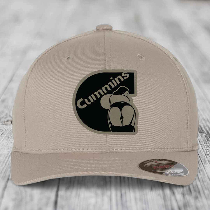Beige baseball cap with black Cummins logo patch featuring a stylized engine design.