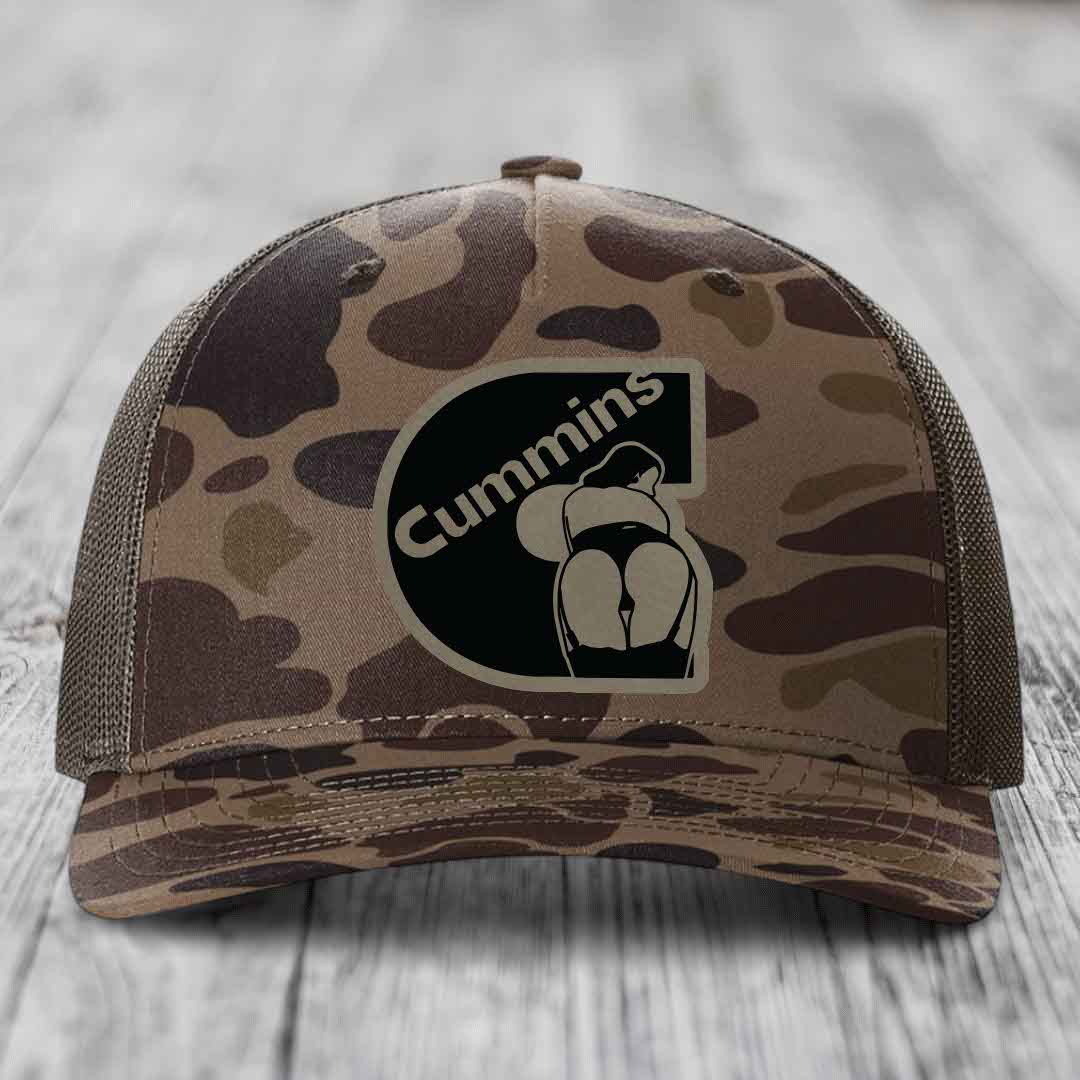 Camouflage trucker hat with black Cummins logo patch on front.