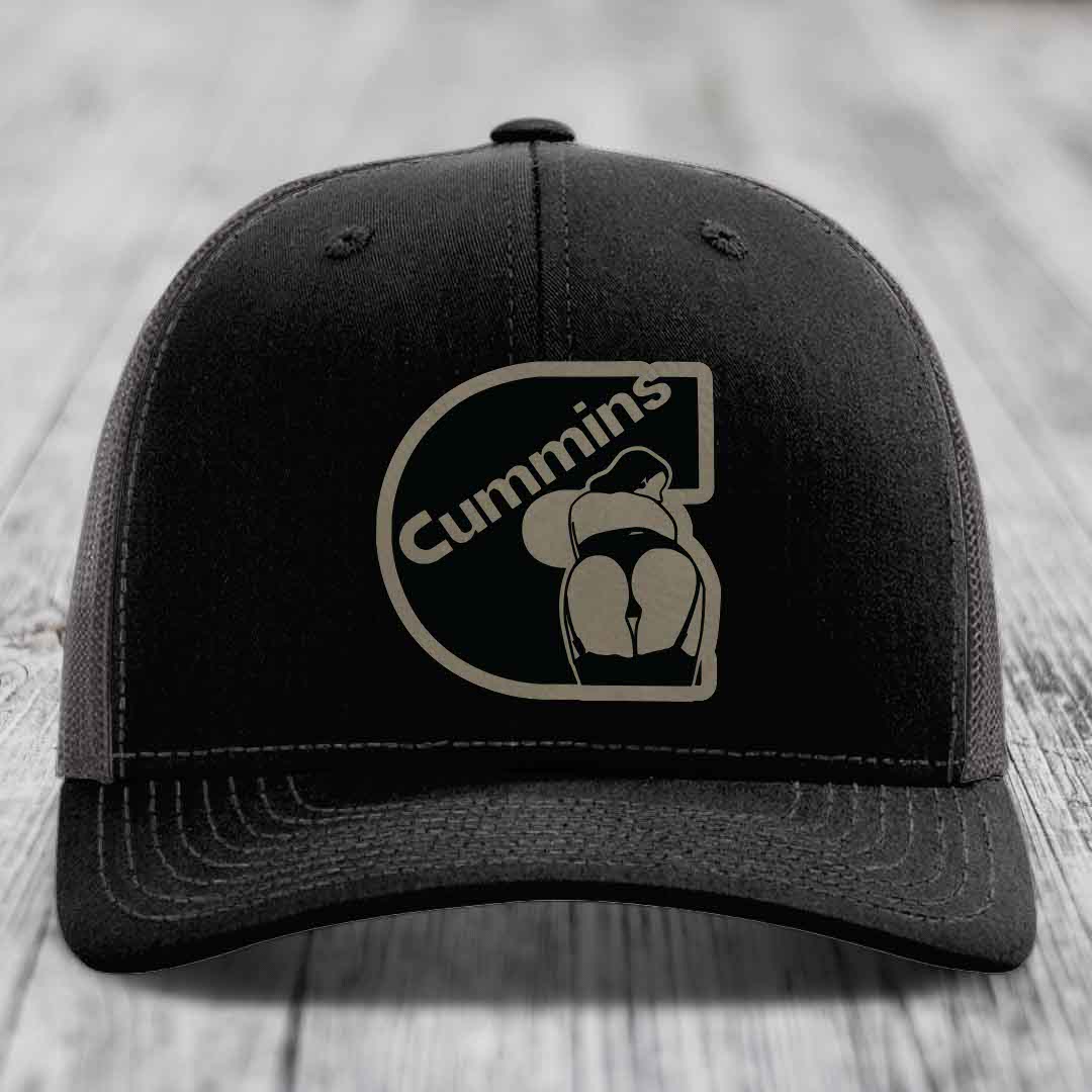 Black trucker hat with white stitching and a Cummins logo patch on the front.