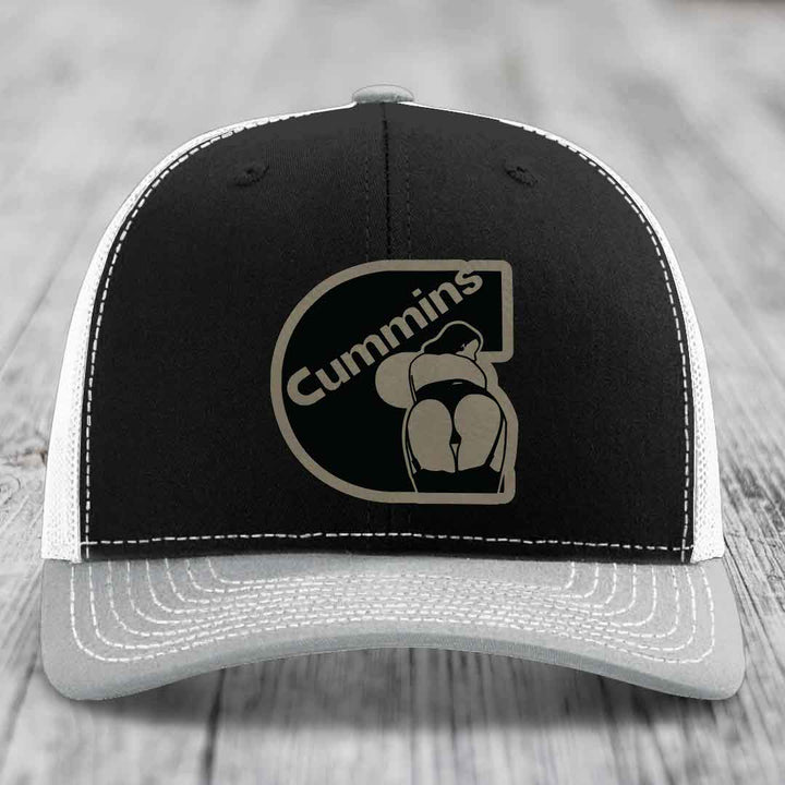 Brown trucker hat with white stitching and a black Cummins logo patch on front.