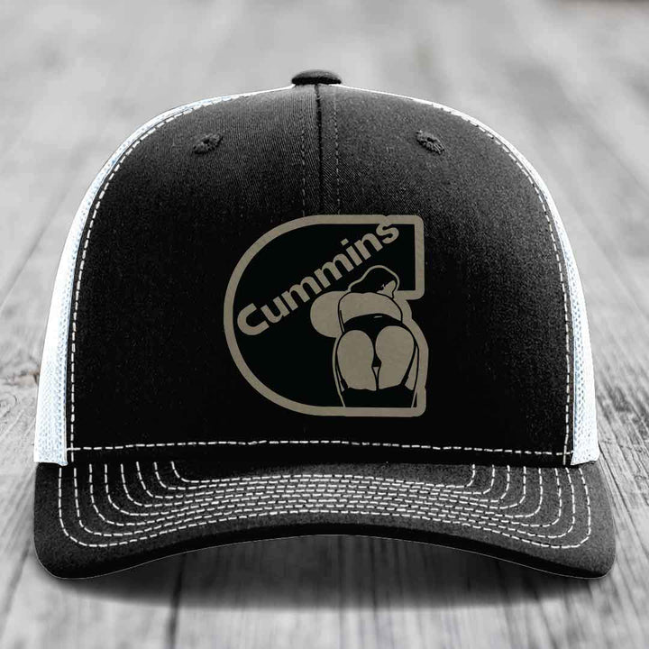 Black and white trucker hat with Cummins logo patch on front.