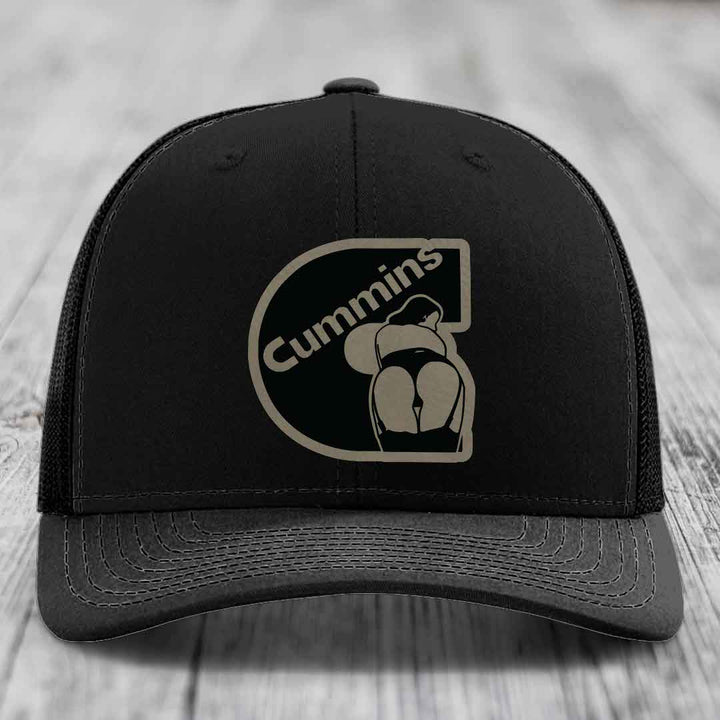 Tan and blue trucker hat with black Cummins logo patch on front.