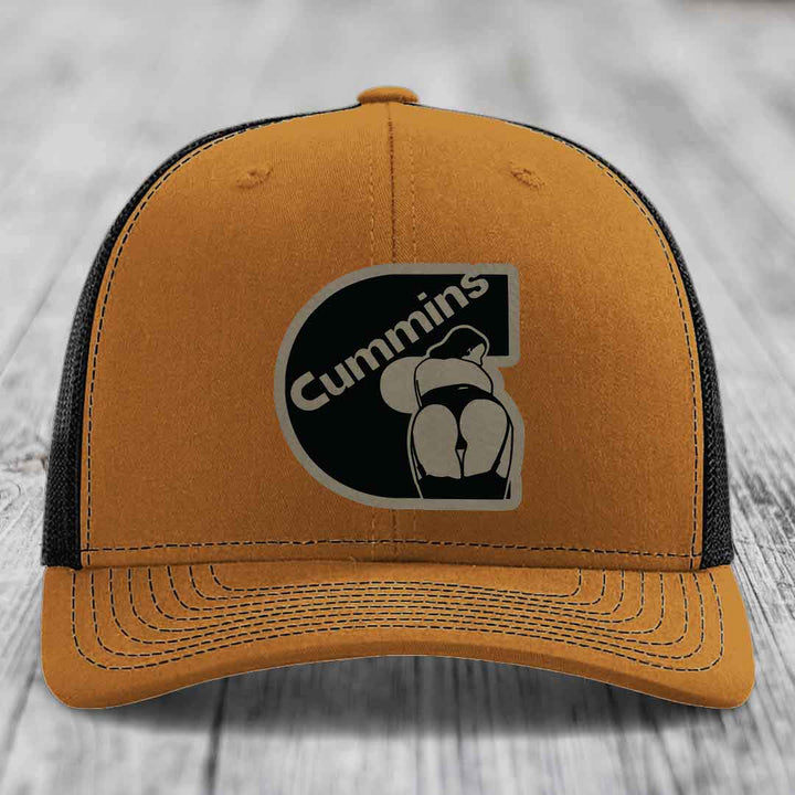 Grey trucker hat with black mesh back and Cummins logo patch on front.