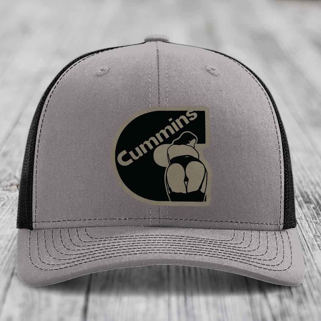 Grey trucker hat with blue mesh sides and a black Cummins logo patch on front.