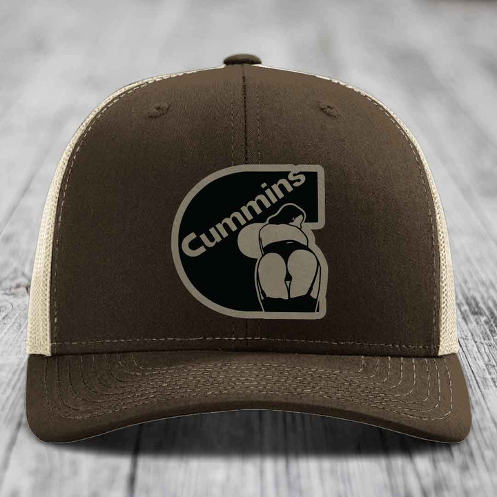 Green trucker hat with Cummins logo patch on front, featuring a stylized &