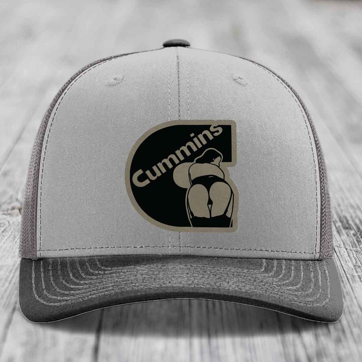 Grey and beige trucker hat with Cummins logo patch on front.